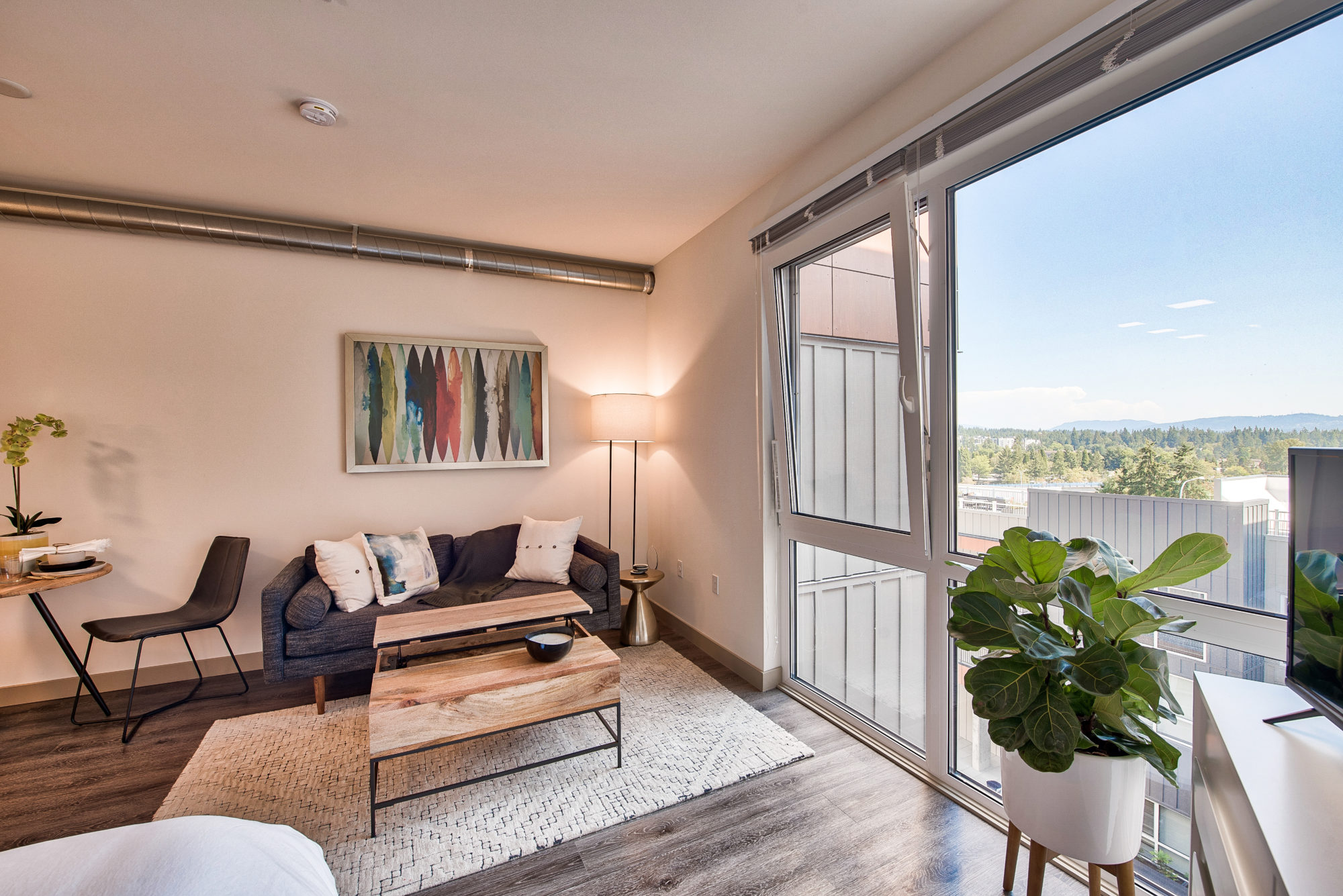 living area with view, hard flooring, windows with views, exposed ventilation.